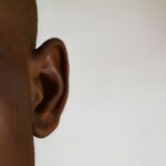un gros plan de l'oreille d'une personne sur fond blanc